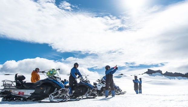 A group ready on snowmobiles
