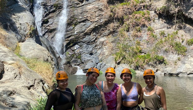 Gruppo di amiche in posa davanti alla cascata