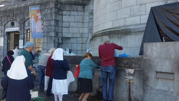 Heiliges Wasser in der Nähe der Grotte holen.